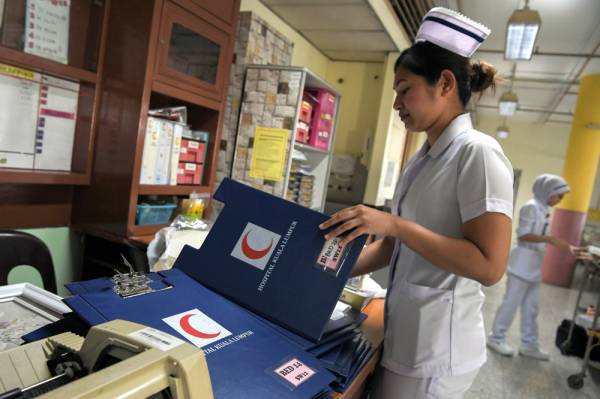 Jururawat Terlatih Hospital Kuala Lumpur (HKL) Nur’atiqah Ismail, 30, sedang menguruskan fail para pesakit di salah sebuah wad yang pernah di khaskan bagi penjagaan pesakit Covid-19 pada Mei lalu. -Foto Bernama