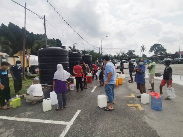 Penduduk di kawasan Rantau beratur menadah air di tangki statik di Dataran Rantau hari ini.