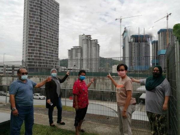 Yoke Teng bersama penduduk menunjukkan kerja meletup batu berhampiran kawasan perumahan mereka.