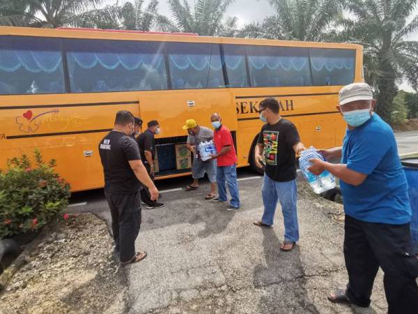 Mohd Zatullah menghantar air mineral dengan bas sekolah untuk kegunaan penduduk yang terjejas bekalan air di Port Dickson.