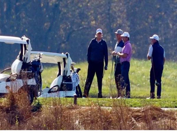 Trump (kiri) menghabiskan masa bermain golf di kelab persendirian miliknya di Trump National Golf Course di Sterling, Virginia semalam. - Foto Agensi