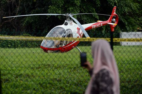 Kelihatan sebuah helikopter yang sempat membuat pendaratan cemas dalam kejadian melibatkan dua helikopter yang dipercayai bertembung di udara sebelum sebuah daripadanya terhempas. -Foto Bernama