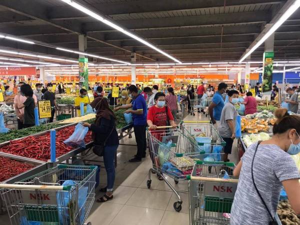 Orang ramai sedang memberi barang keperluan di sebuah pasar raya di Cheng, Melaka hari ini.