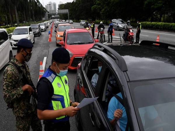 Anggota polis dan Angkatan Tentera (ATM) kelihatan memeriksa dokumen perjalanan para pengguna jalan raya pada sekatan jalan raya (SJR) di Lebuhraya Tun Dr Lim Chong Eu menghala ke Jambatan Pulau Pinang berikutan perlaksanaan Perintah Kawalan Pergerakan Bersyarat (PKPB) di seluruh negeri Pulau Pinang hingga 6 Disember. - Foto Bernama
