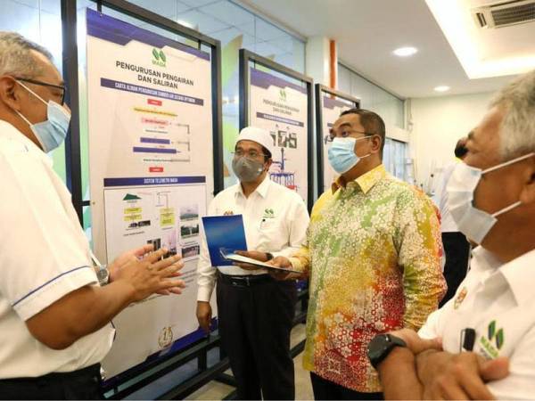 Muhammad Sanusi (dua dari kanan) mendengar taklimat berkaitan pengurusan pengairan dan saliran ketika melawat ruang pameran MADA di Alor Setar baru-baru ini.