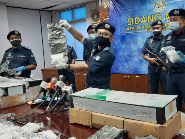 Johari (tengah) menunjukkan rampasan methamphetamine yang dibungkus dengan bungkusan timah pada sidang akhbar di Kompleks Pencegahan Negeri JKDM Pulau Pinang, Perai hari ini.