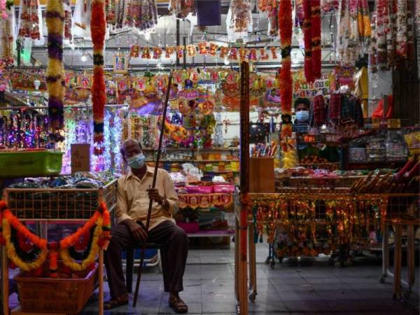 Kelihatan pekerja sebuah premis di Little India, termenung ekoran ketiadaan pelanggan yang datang untuk membeli di premisnya semalam. - Foto Bernama 