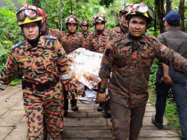 Anggota bomba mengusung mayat mangsa yang berjaya dikeluarkan dari lokasi kejadian tanah runtuh di sebuah resort pelancongan di Tambun hari ini. - Foto Bernama