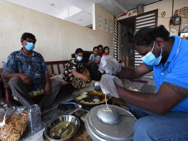  Pembuat muruku A. Jayachanthiran (kiri) dibantu isteri M. Thivanney, dan anaknya Prakash Kumar, bersama-sama menyiapkan tempahan muruku menjelang sambutan perayaan Deepavali ketika tinjauan di rumahnya di Taman Shahzan hari ini. - Foto Bernama