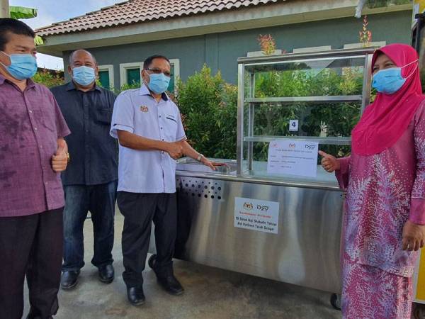 Shabudin (tiga dari kiri) menyampaikan bantuan peralatan perniagaan kepada salah seorang penerima di Tasek Gelugor hari ini.