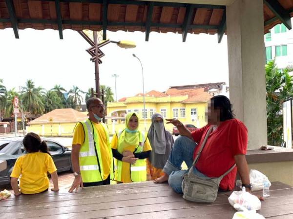 Wakil NGO dan Hotel Ummi Sue menyapa salah seorang gelandangan di sekitar bandar Kota Bharu semalam.