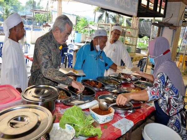 Pengunjung terdiri daripada pelbagai lapisan masyarakat memilih lauk-pauk untuk dinikmati bersama nasi putih dan minuman yang disediakan di Warung Nadzri, Jertih hari ini.- Foto Bernama