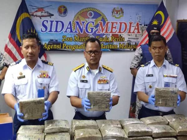 Mohd Zawawi menunjukkan ketulan ganja mampat yang dirampas pada sidang media di Pejabat Zon Maritim Kuala Perlis hari ini. - Foto FB APMM