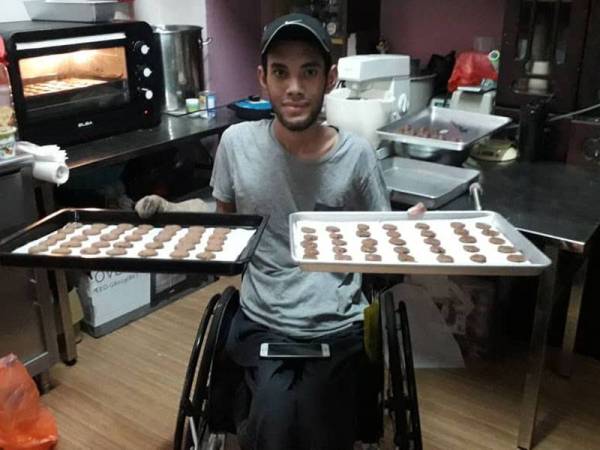 Mohamad Sufian menunjukkan biskut coklat chip yang dihasilkan di rumahnya di Taman Bahagia, Johor Bahru hari ini.