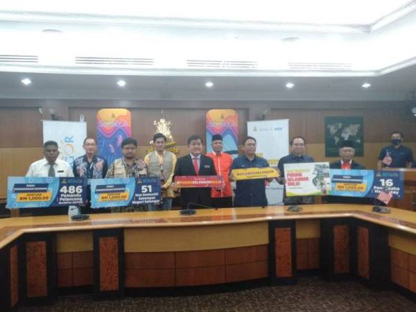 Loy Sian (lima dari kanan) menyampaikan bersasar secara 'one-off' RM1,000 seorang kepada seramai 553 penggiat industri pelancongan di Selangor semalam.