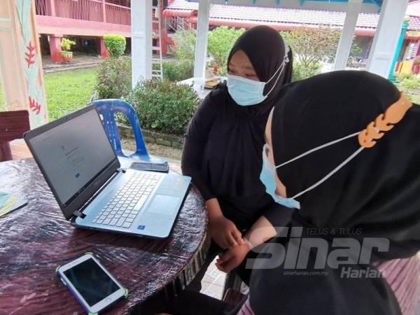 Nor Ain Liyana (kiri) dan Nur Syazana sukar untuk mengikuti pembelajaran dalam talian berikutan capaian internet yang terhad di PPS SK Parit Aman, Bagan Serai. 