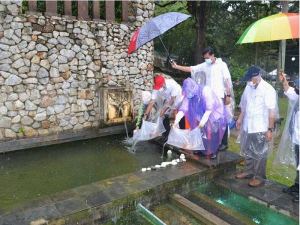 Hamdan (tengah) menyaksikan pelepasan ikan koi pada Program satu warga satu ikan dan penyampaian hadiah pertandingan sempena Kuantan Bandaraya Lestari di Zoo Mini Teruntum, hari ini.