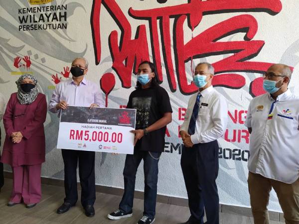 Annuar (tiga dari kiri) menyampaikan hadiah kepada pemenang tempat pertama kategori mural PBKL di Kuala Lumpur hari ini.