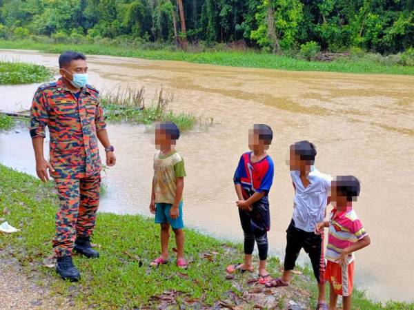 Azhar Elmi memberikan nasihat kepada kanak-kanak yang sedang bermain air di Kampung Tasek, Tok Kundor, Bukit Awang, Pasir Puteh ketika membuat tinjauan di kawasan tersebut.