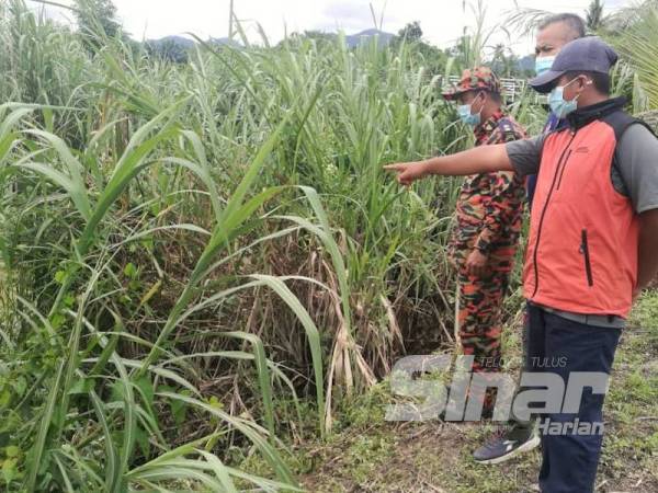 Mohd Syawal (kanan) menunjukkan lokasi terakhir mangsa sebelum hilang selepas mendapat bantuan.