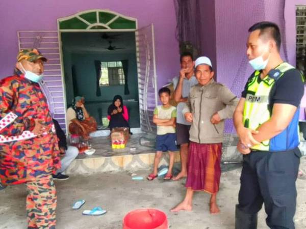 Zainal (dua dari kanan) ketika menerima kunjungan dari Azmir (kanan) dan Azhar Elmi (kiri) di rumahnya di Kampung Tasek, Tok Kundor, Pasir Puteh hari ini.