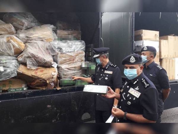 Ayob Khan (kanan) menunjukkan rokok seludup yang dirampas sejak 2018 hingga bulan lalu sebelum dilupuskan pada sidang akhbar di IPK Johor, Johor Bahru hari ini.