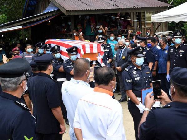 Anggota polis mengusung keranda mendiang Koperal Baharuddin Ramli dengan penuh istiadat PDRM untuk dikebumikan di Tanah Perkuburan Orang Asli Kampung Sungai Sampo, Jempol, hari ini.