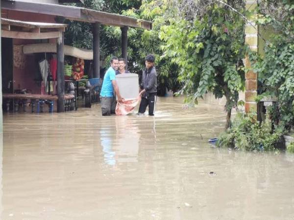 Penduduk di Kampung Petaling, Kuala Nerus memindahkan barangan selepas kediaman mereka dinaiki air.