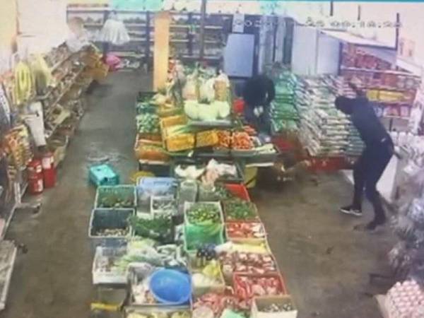 Rakaman CCTV menunjukkan dua lelaki berpakaian gelap dan bertopeng telah menetak mangsa dengan menggunakan parang panjang di sebuah kedai runcit di Teluk Intan semalam. - Foto ihsan pembaca