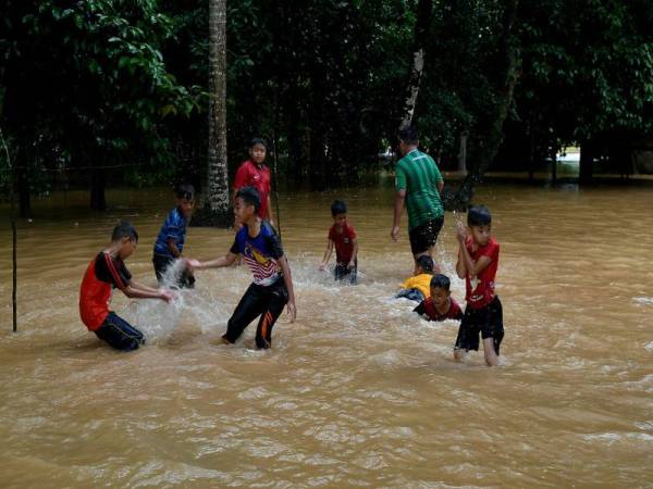 Sekumpulan kanak-kanak bermain banjir di Kampung Bukit Tadok, Kuala Telemong hari ini. - Foto Bernama