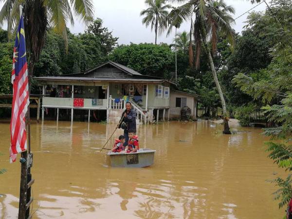 Mohd Kamarzaman terpaksa menggunakan perahu kerana kediamannya di Kampung Bukit Tadok, Hulu Terengganu dinaiki air.