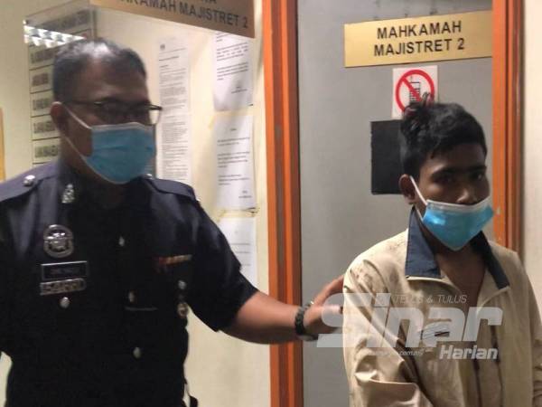 Pihak polis membawa Nor Hakim (kanan) ke Mahkamah Majistret Ampang hari ini atas dakwaan mencuri dua minggu lalu.