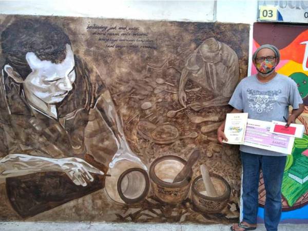 Munif bersama hasil seni muralnya yang terpilih menjadi juara pertandingan mural peringkat daerah Maran tahun ini.