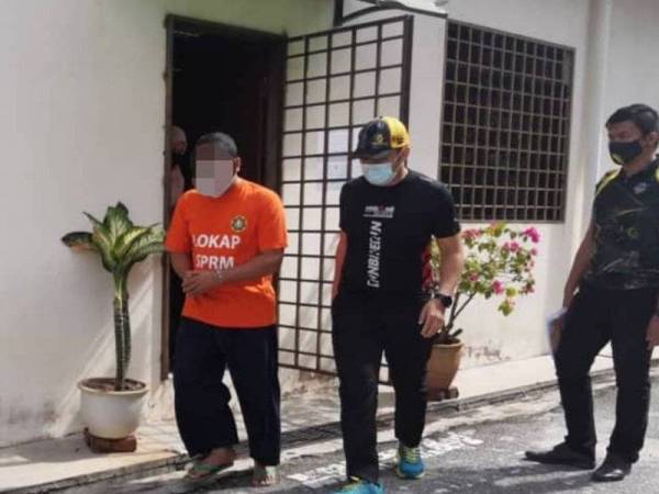 CEO (kiri) sebuah anak syarikat kerajaan Perak keluar dari Mahkamah Majistret Ipoh selepas mendapat perintah reman selama dua hari bermula hari ini bagi membantu siasatan kes dokumen palsu.