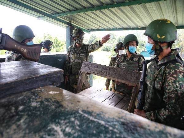 Arman (dua dari kiri) ketika membuat lawatan di pos kawalan dalam kawasan Ops Pagar II di sempadan Bukit Kayu Hitam hari ini.