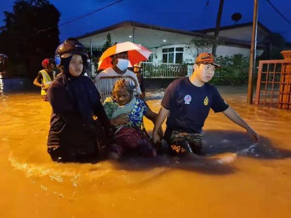 Penduduk di Kampung Ming Terk, Batu Dua, Kulim hari ini dibawa keluar oleh anggota penyelamat ke kawasan selamat. - Foto APM KULIM