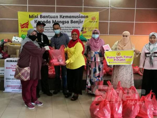 Hamidah (tengah) menyampaikan sumbangan secara simbolik kepada wakil sukarelawan sebelum edaran dibuat kepada mangsa banjir di tiga kampung yang terjejas akibat banjir kilat di Dewan Komuniti Kampung Cempaka Sari hari ini.