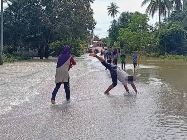 Orang ramai memenuhi kawasan yang dinaiki air di Gual Tok Deh untuk bermain air.