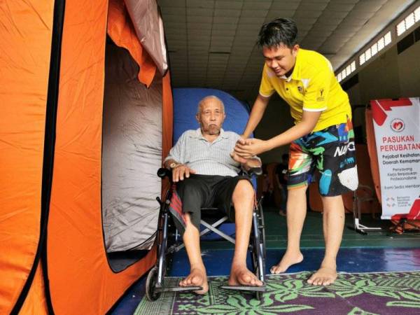 Azman bersama bapanya di PPS Dewan Sivik Felda Seberang Tayor, Kemaman.