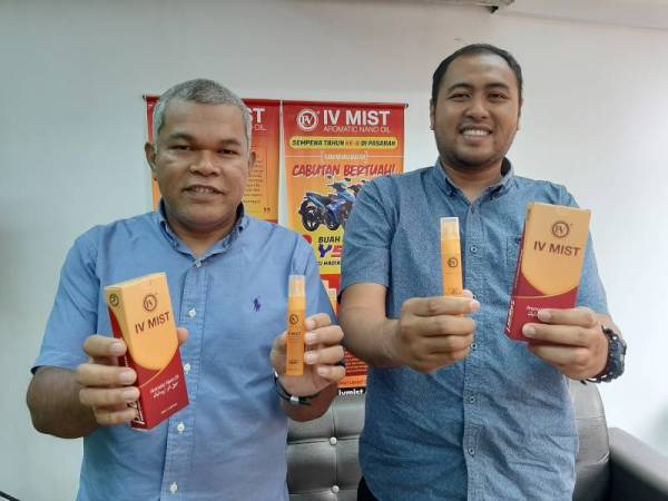 Ahmad Sidry (kiri) bersama pengurusnya, Muhammad Adam menunjukkan produk IV Mist.