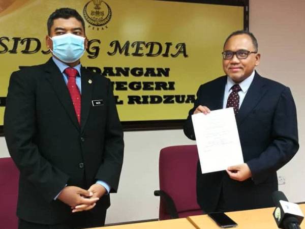 Mohamad Zahir (kanan) menunjukkan teks sidang akhbar yang dibaca pada sidang akhbar di Bilik Sidang Media DUN Perak Bangunan Perak Darul Ridzuan, Ipoh hari ini.