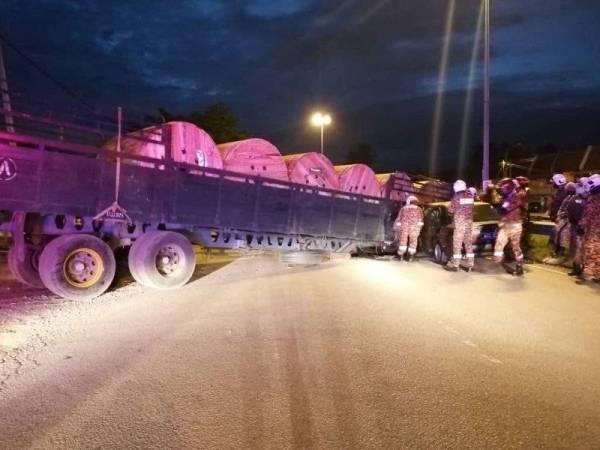 Anggota bomba mengeluarkan seorang warga emas selepas kereta dipandunya melanggar sebuah treler di Jalan Kesang, Tangkak hari ini.