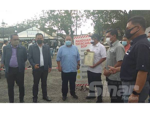 Abd Rahim (tiga, kanan) menyampaikan sijil penarafan kepada Mohd Khairul Hisham (tiga, kiri) disaksikan Hamdan (dua, kanan) di Pusat Jaja Dataran Sekilau di Kuantan hari ini.