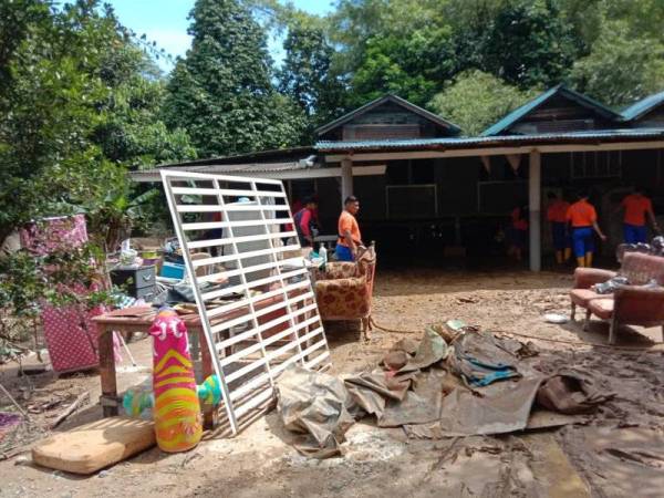 Pasukan APM membantu membersihkan rumah penduduk di Kemaman yang ditenggelami air selepas banjir pulih. - Foto APM