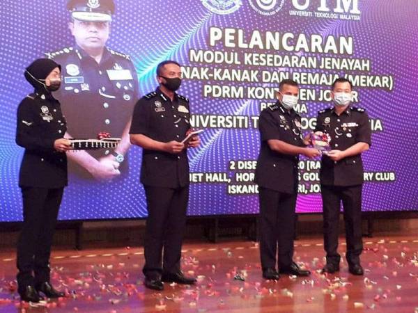 Ayob Khan menyerahkan modul Mekar kepada Ahmad Fauzi selepas pelancaran Modul Kesedaran Jenayah, Dadah dan Sosial (Mekar) di Horizon Hills Golf and Country Club, Iskandar Puteri hari ini.