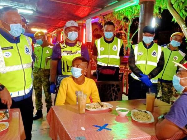 Mohamad Roy (kiri) turun padang meninjau operasi pematuhan SOP di premis perniagaan makanan sekitar jajahan ini malam tadi.