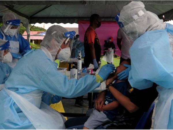 Petugas kesihatan mengambil sampel saringan Covid-19 ke atas penduduk yang hadir ketika tinjauan di Dewan Orang Ramai Meru 3 Klang semalam. - Foto Bernama