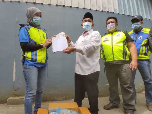 Tosrin (tiga dari kanan) menunjukkan sijil halal yang dipercayai palsu sewaktu tinjuan dilakukan ke atas sebuah gudang pembekal makanan sejuk beku di Taman Perindustrian Senai hari ini.