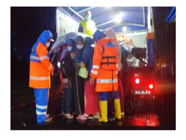 Pasukan APM membantu memindahkan penduduk yang terjejas banjir di Kuala Besut, Besut. Foto: APM