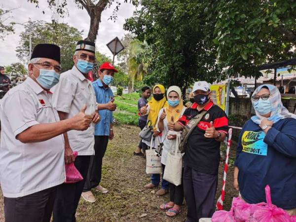 Mohammad Asri (dua dari kanan) bersama Zamri (tiga dari kiri) dan Ahmad (dua dari kiri) pada Program Pemberian Ikan Mentah kepada penduduk sekitar Kota Setar di depan Medan Selera Taman Wira Mergong, Alor Setar hari ini.